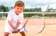 Boy playing tennis and looking very happy